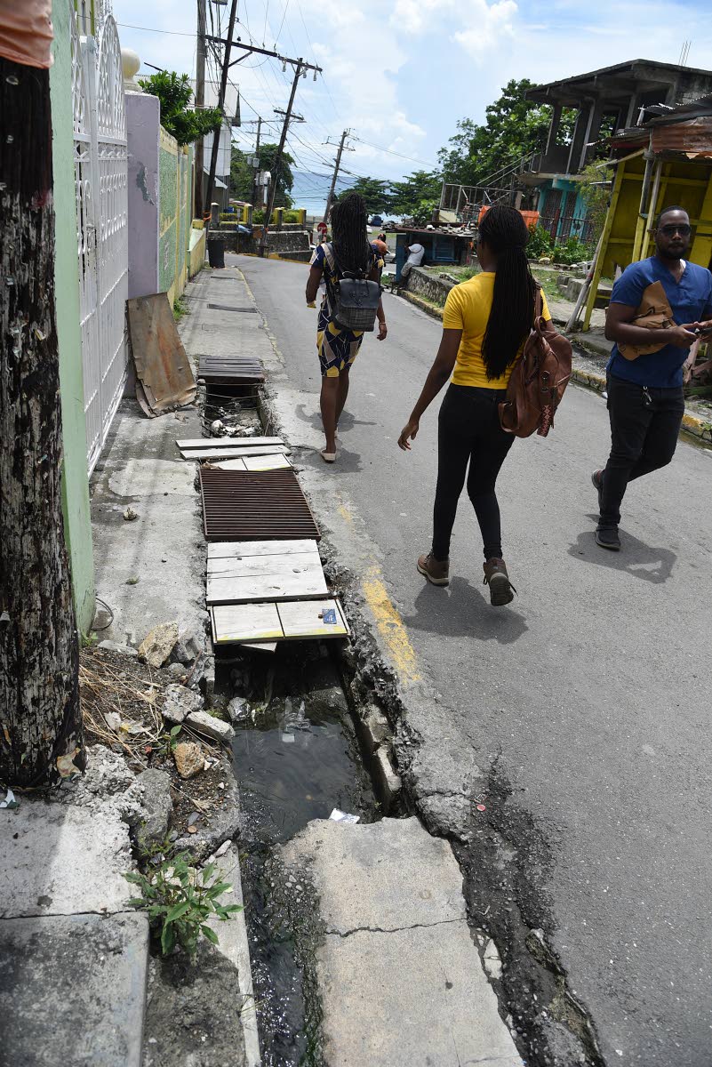 Pedestrians were forced to walk in the streets along Rosemary Lane in Morant Bay, St Thomas, last week because of missing drain covers.