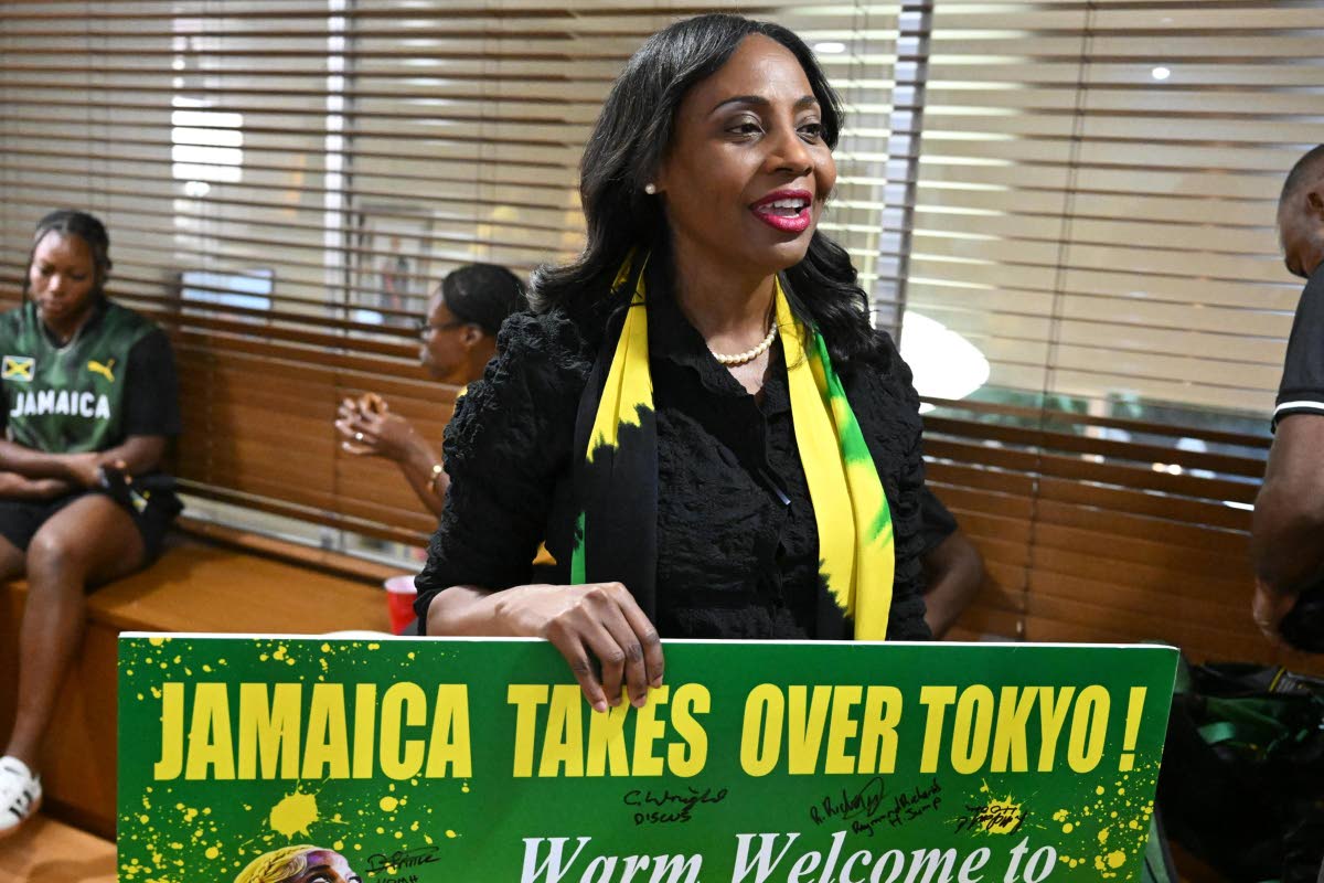 Her Excellency Shorna-Kay Richards brandishes a ‘Jamaica takes over Tokyo’ banner during a welcome ceremony for Jamaica’s athletes at the country’s Embassy in Tokyo on Wednesday.  