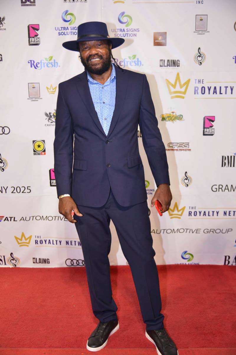 Tony Rebel pairs his fedora with a navy suit. 