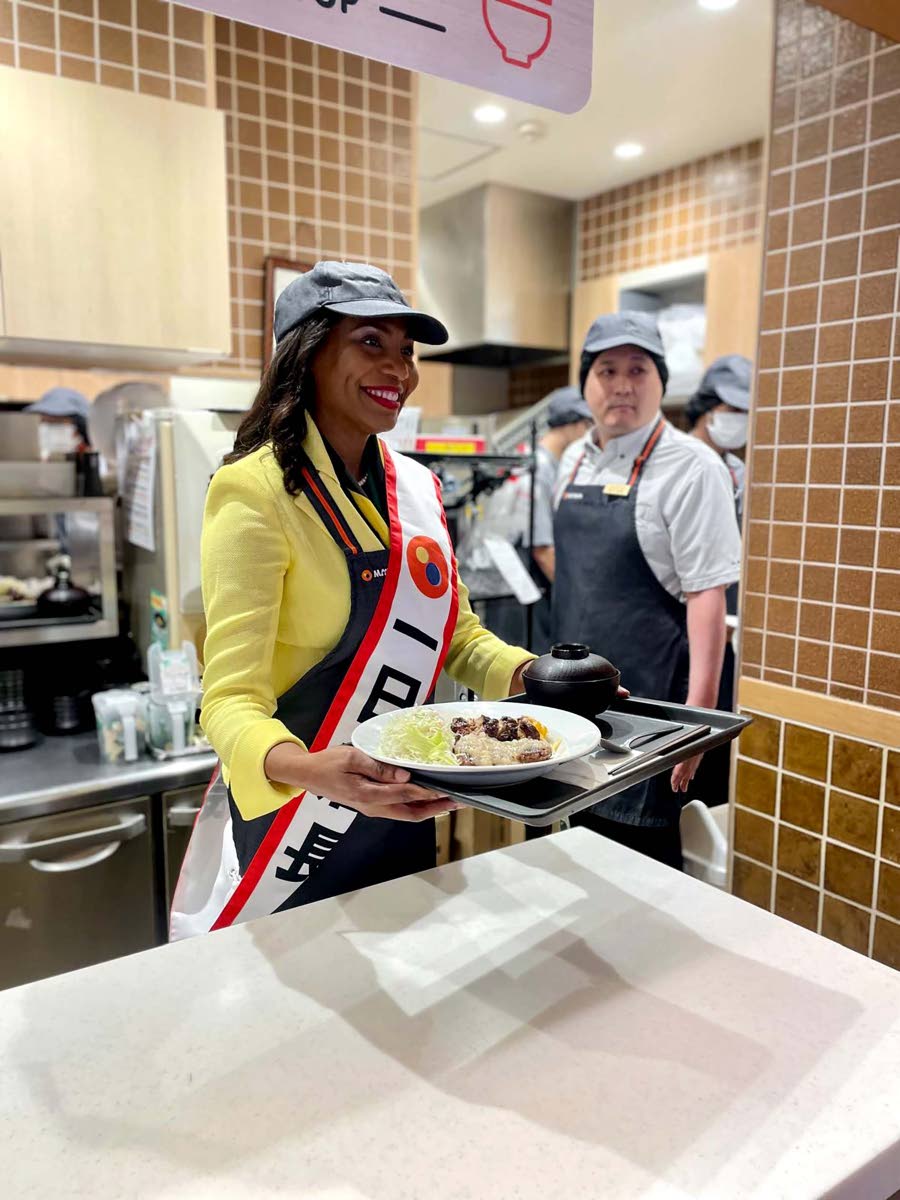 Jamaican Ambassador to Japan Shorna-Kay Richards serves up an order of jerk chicken at Matsuya.