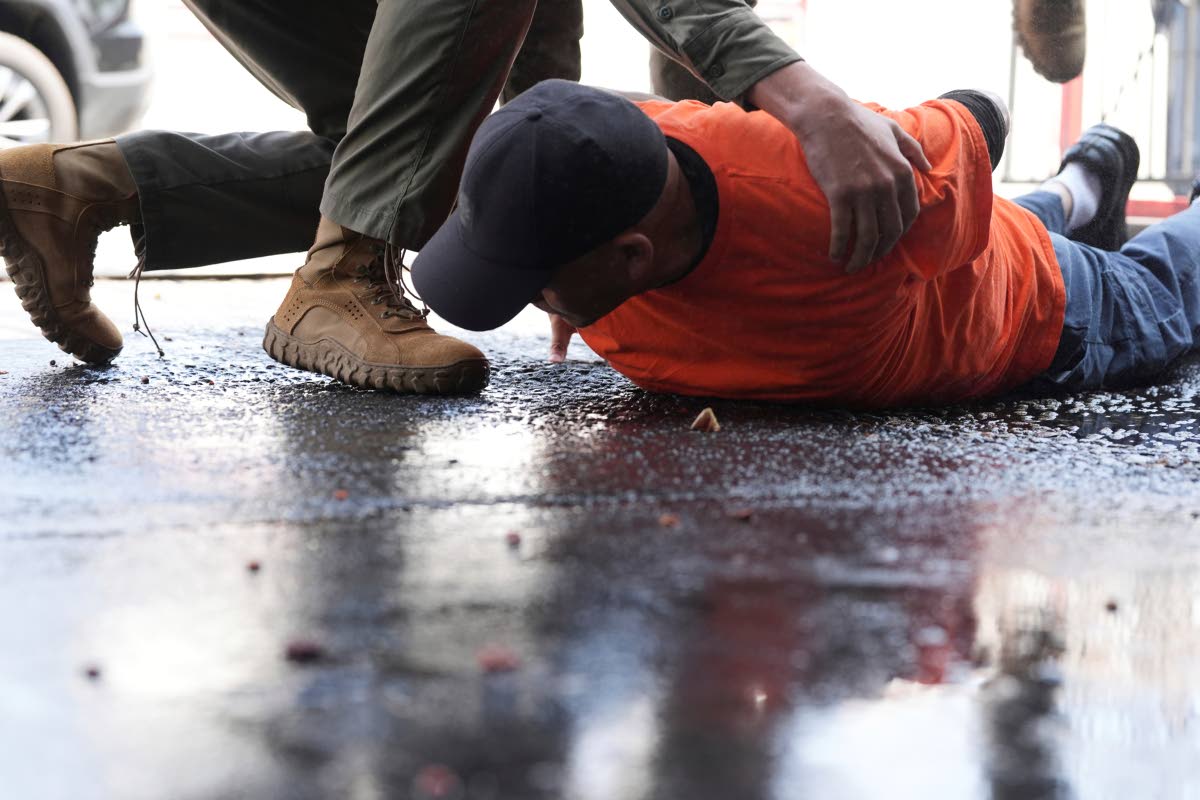 A man is detained by immigration agents at a car wash on Friday, August 15, in Montebello, California. 