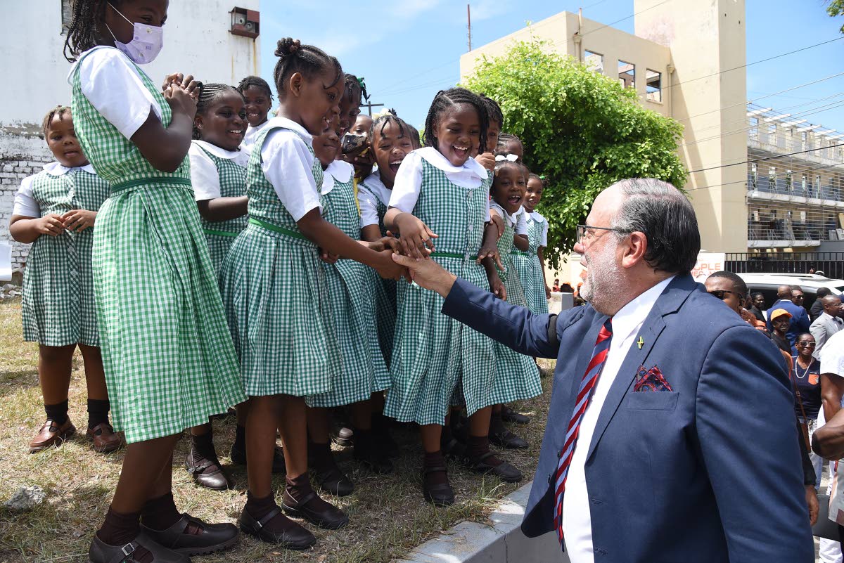 Opposition Leader Mark Golding (right) greets students of St George’s Primary School on his way to Gordon House for the swearing-in ceremony for legislators on Thursday.