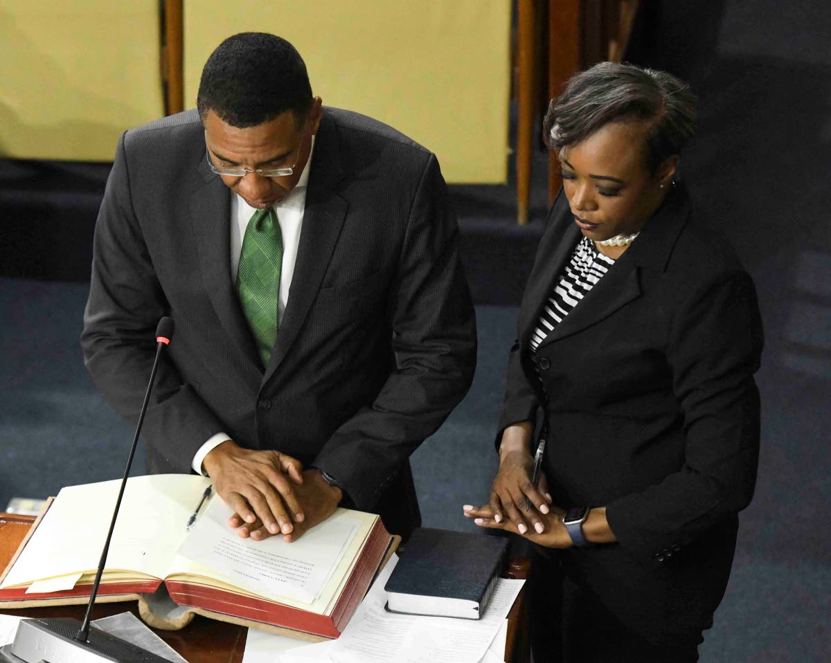 Prime Minister Dr Andrew Holness, member of parliament for St Andrew West Central, takes the oath of allegiance under the guidance of House Clerk Colleen Lowe during Thursday’s proceedings.