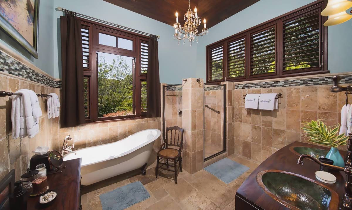 A chandelier bathroom with copper vanity basins.