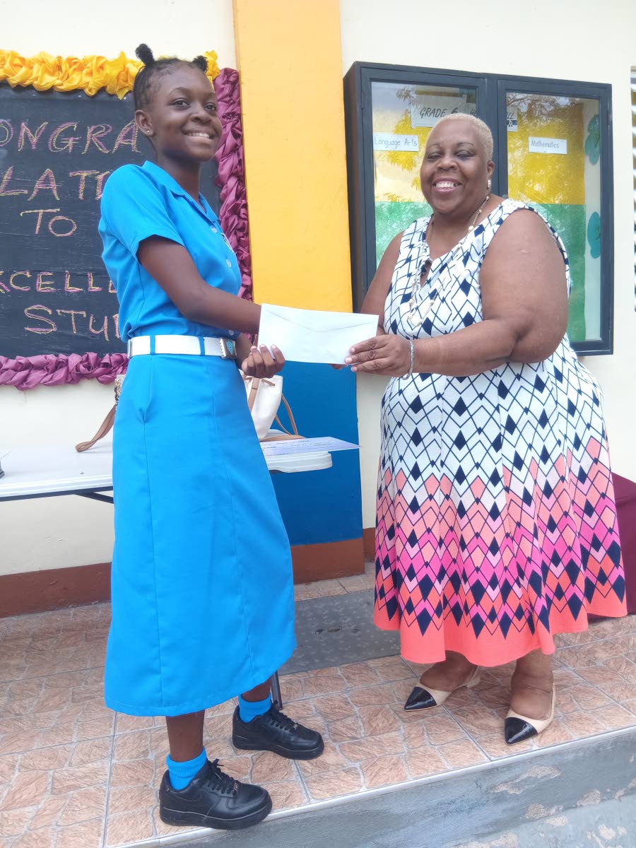 Pastor Marcia Wright presents the runners-up cheque to Kaminda Barnett at Glowell Preparatory School. 