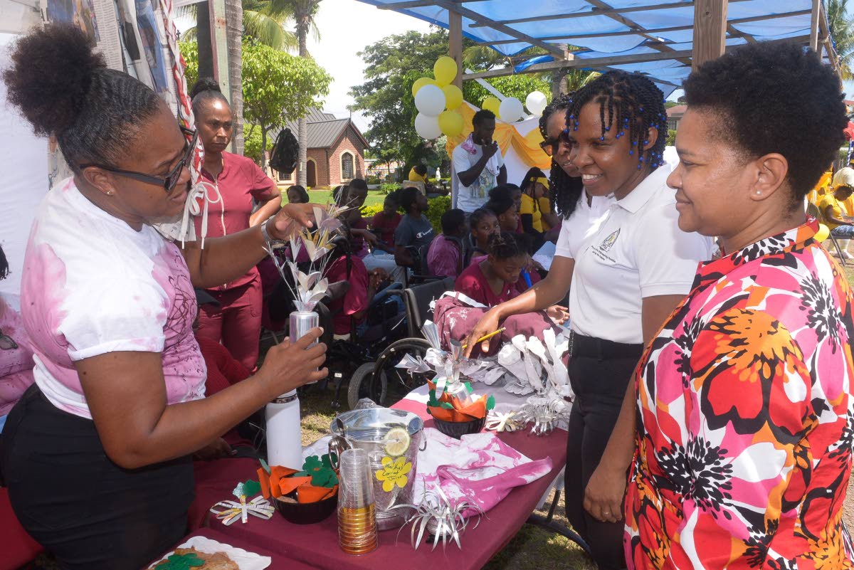 Special needs coordinator at the Ministry of Education, Skills, Youth and Information, Nicolette Thompson (right), and children’s officer at the Child Protection and Family Services Agency (CPFSA), Jesanya Scale-Menzies (centre), observe as caregiver fro