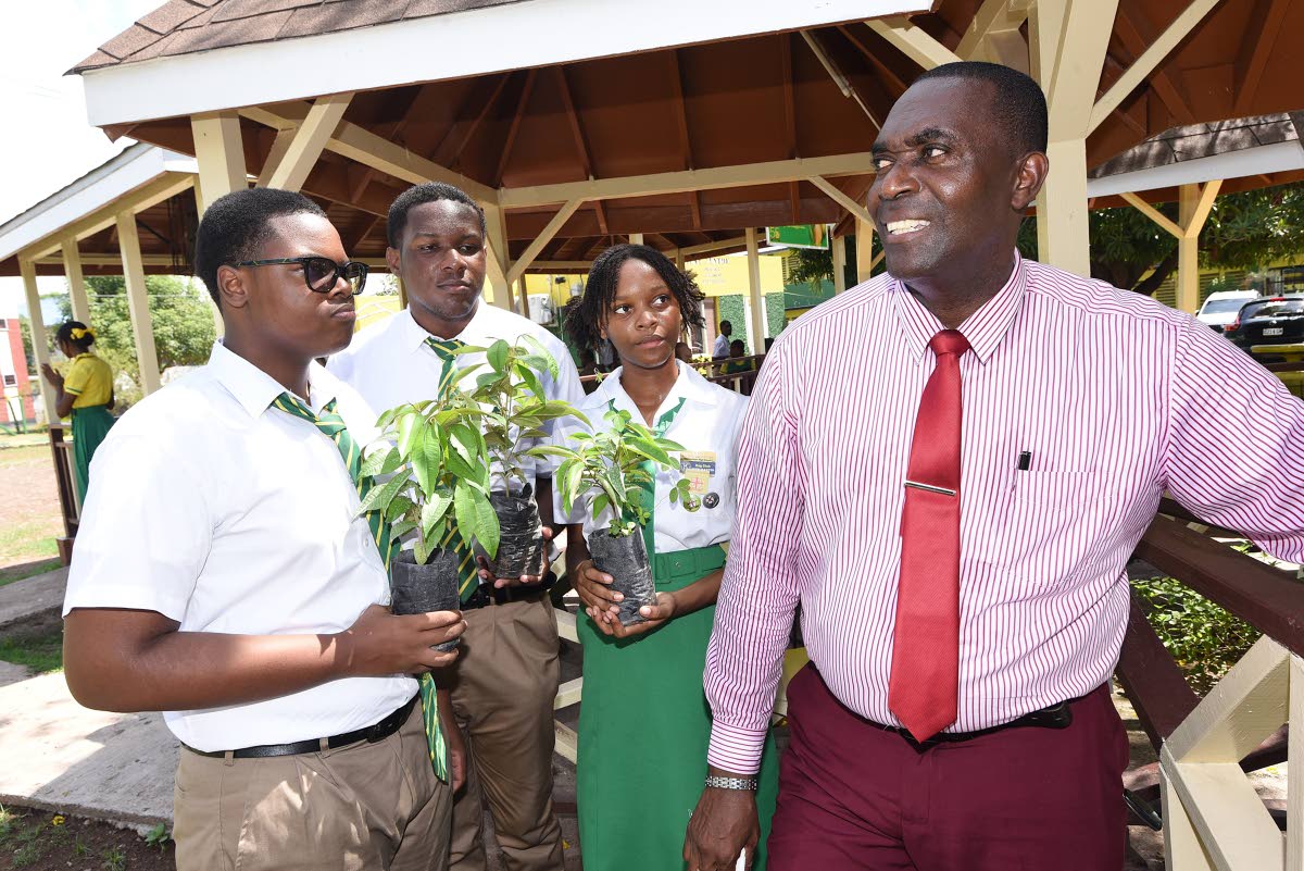 Weir explains the importance of trees to Ato-Daniel Francis (from left), Antoine Richards and Rhodae Rose, students at the school, during a tree planting exercise at the school.