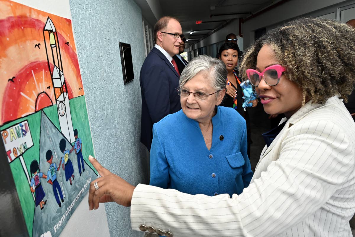 Senator Dr Dana Morris Dixon (right), minister of education, skills, youth and information, looking at artwork and a plaque in special dedication to the high school building alongside Sally Porteous (centre) while looking on are David Harris (left), presid