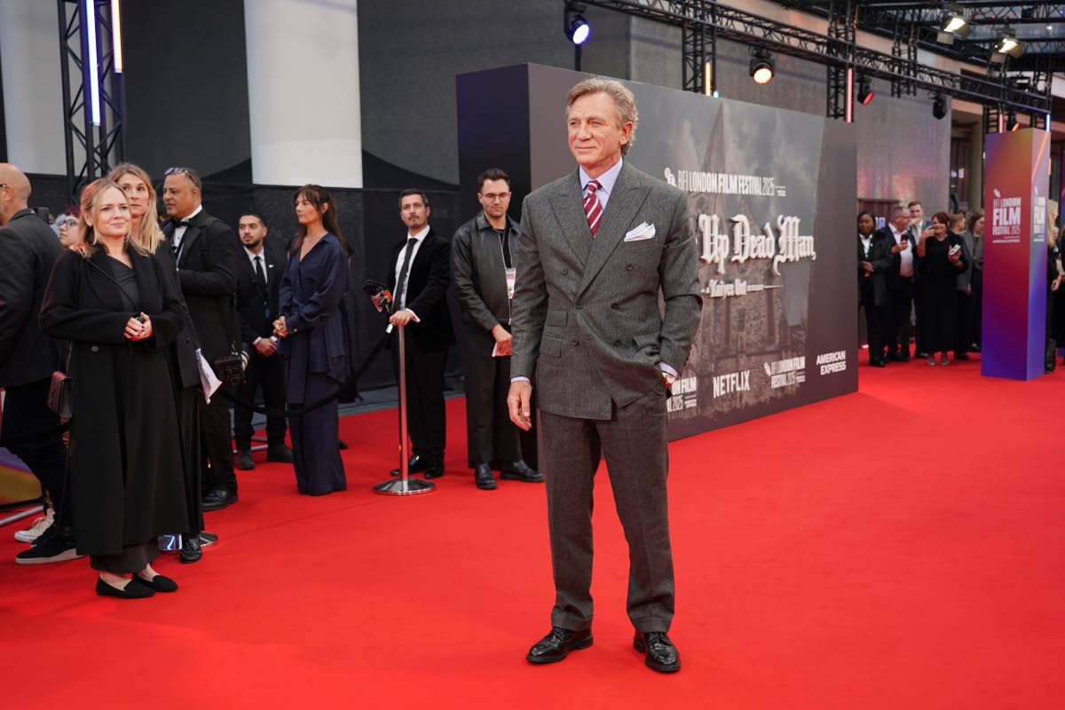 Daniel Craig pulls on Savile Row excellence in an Anderson & Sheppard House Special grey herringbone flannel suit. 