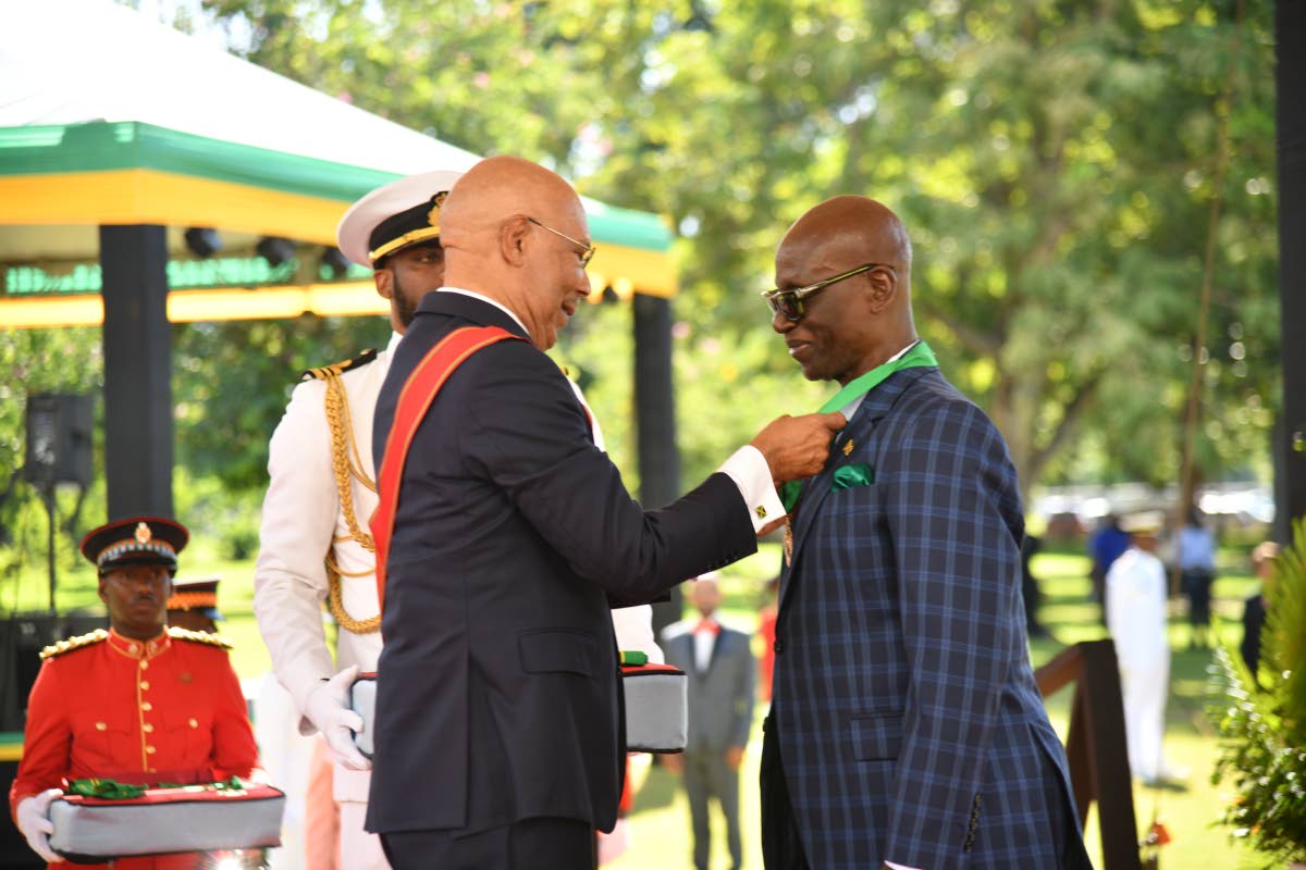 Desmond McKenzie, minister of local government and community development, before Governor General Sir Patrick Allen to receive his membership in the Order of Jamaica on the lawns of King’s House in St Andrew yesterday. 