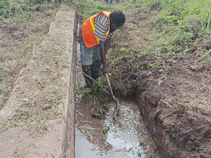 Marcus Brown clears a drain along the Old Harbour Bay main road in St Catherine in preparation for Tropical Storm Melissa. 
