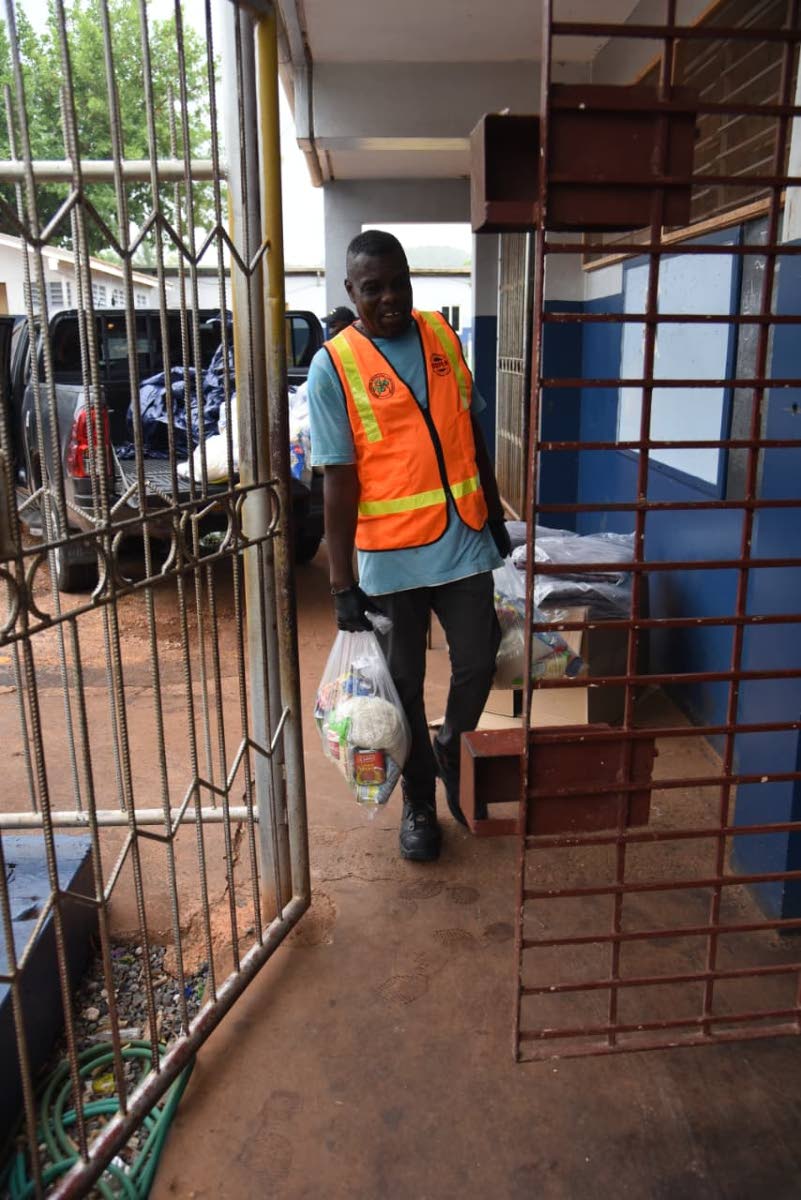 Windel Anderson, shelter manager, New Forest High School Shelter, carries supplies inside the facility on October 26, 2025. 