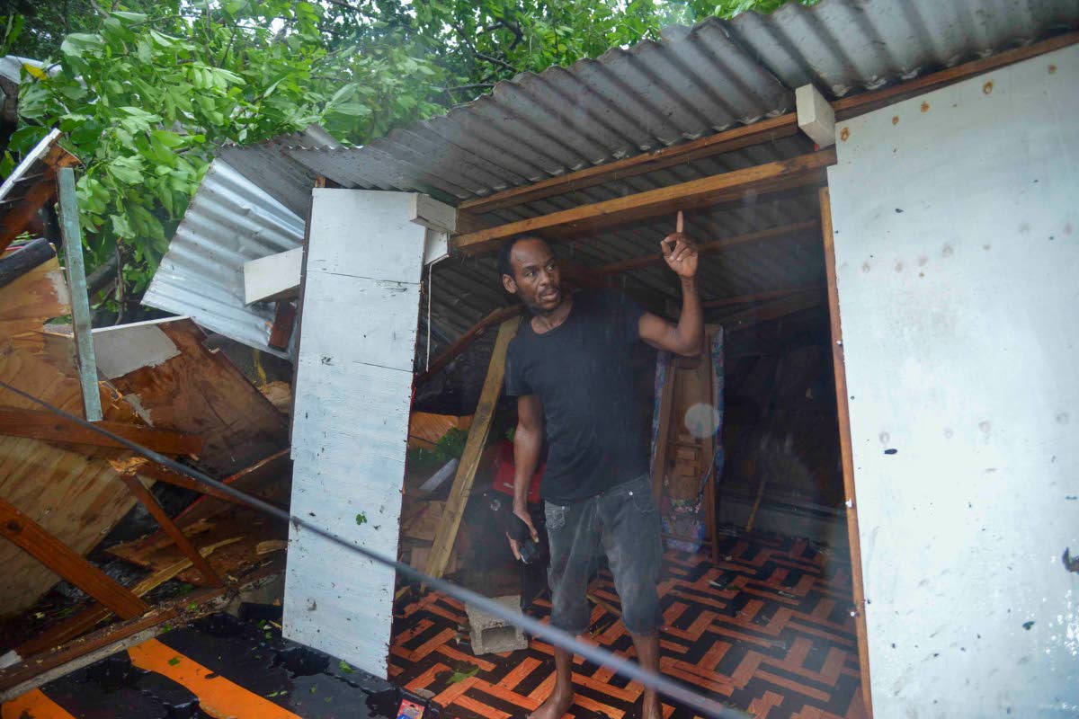 Pernel Wright, a resident of Walker’s Avenue in Gregory Park, St Catherine shows the extent of damage done to his house by a downed tree.