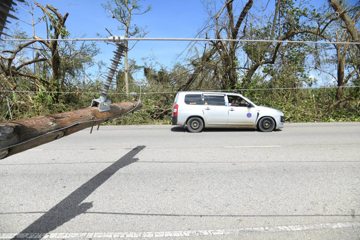 Motorists drive past a downed light pole along the St Ann’s Bay main road in St Ann, following the passage of Hurricane Melissa on Wednesday.
