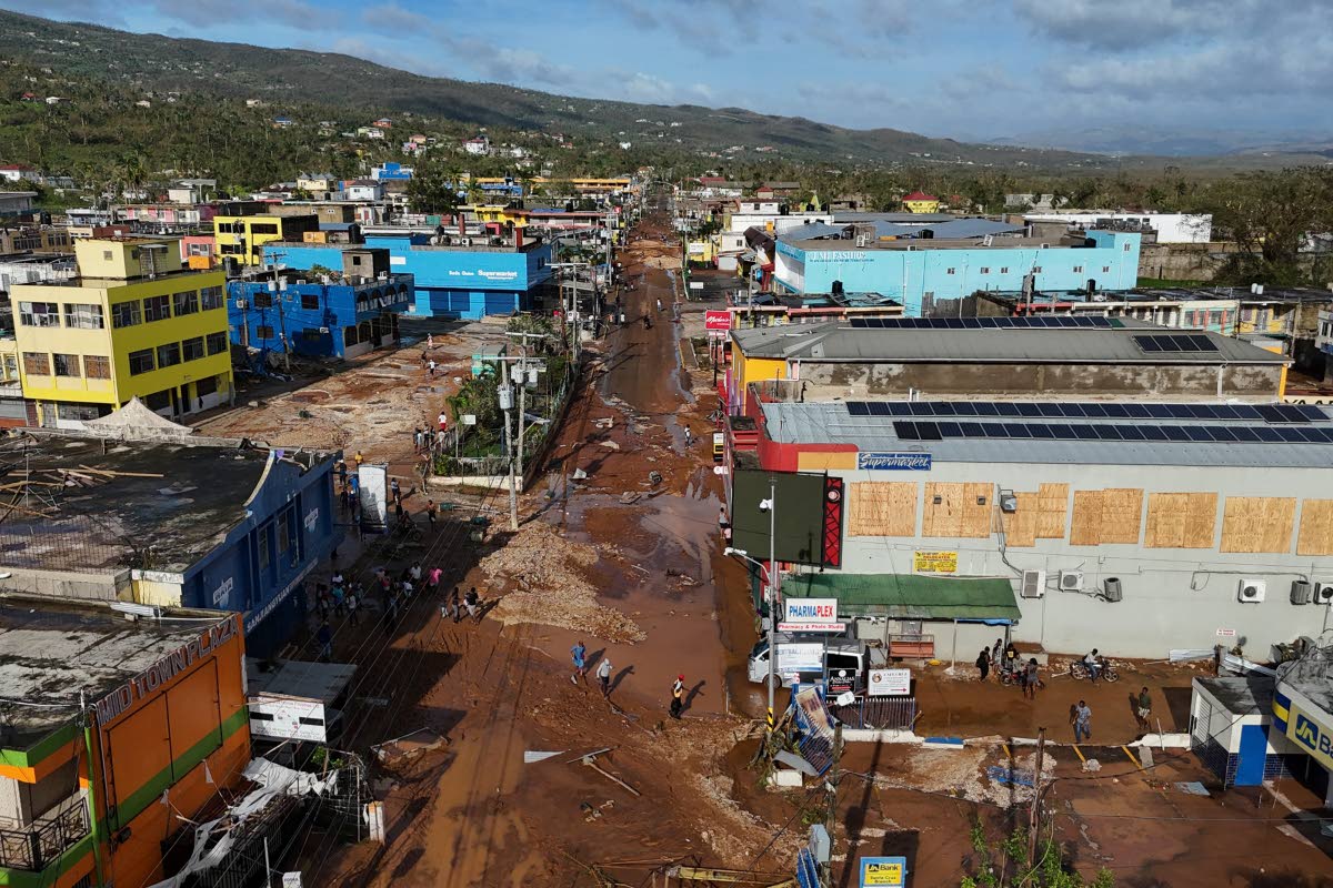 Residents walk through Santa Cruz, Jamaica, after Hurricane Melissa passed. 