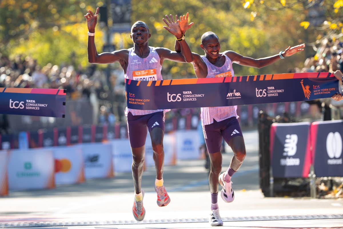 Benson Kipruto (left) and Alexander Mutiso cross the finish line to win first and second place, respectively, in the men’s elite division of the New York City Marathon yesterday in New York. 