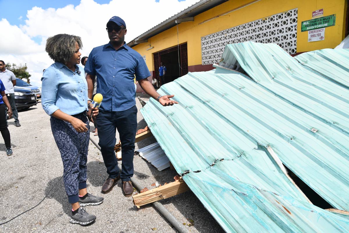 Minister of Education, Skills, Youth and Information, Senator Dr Dana Morris Dixon (left), listens to Hidran McKulsky, principal of Manchester-based Holmwood Technical High School, while on a visit to the institution on Sunday to see the extent of the hurr