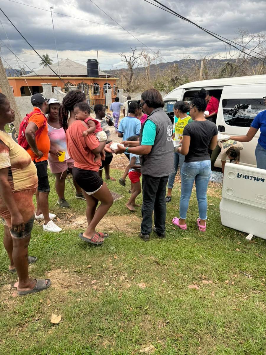 ADRA Jamaica representatives distributing food in Cuffies Pen, Lacovia, St Elizabeth, on  Sunday. 