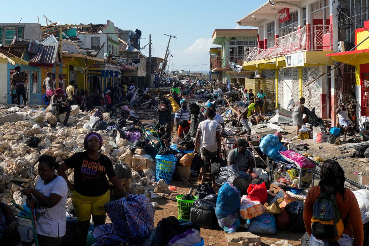 Residents gather amid debris in the aftermath of Hurricane Melissa on a street in Black River, Jamaica, on October 30.