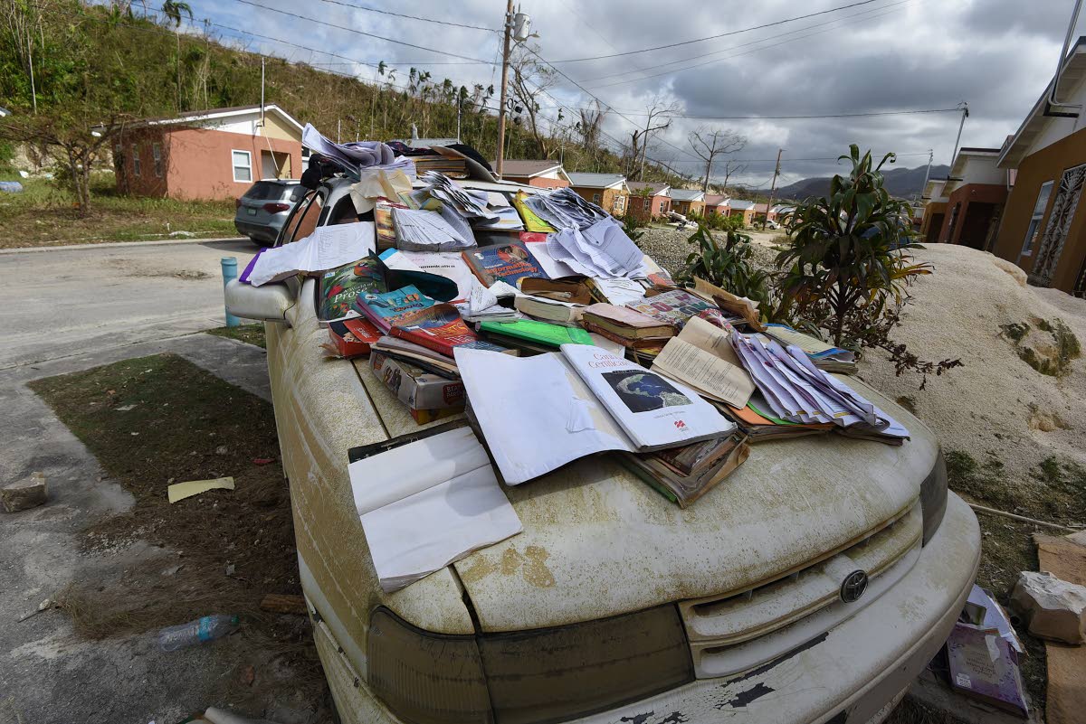 
Residents trying to salvage schoolbooks damaged by floodwaters in The Estuary.