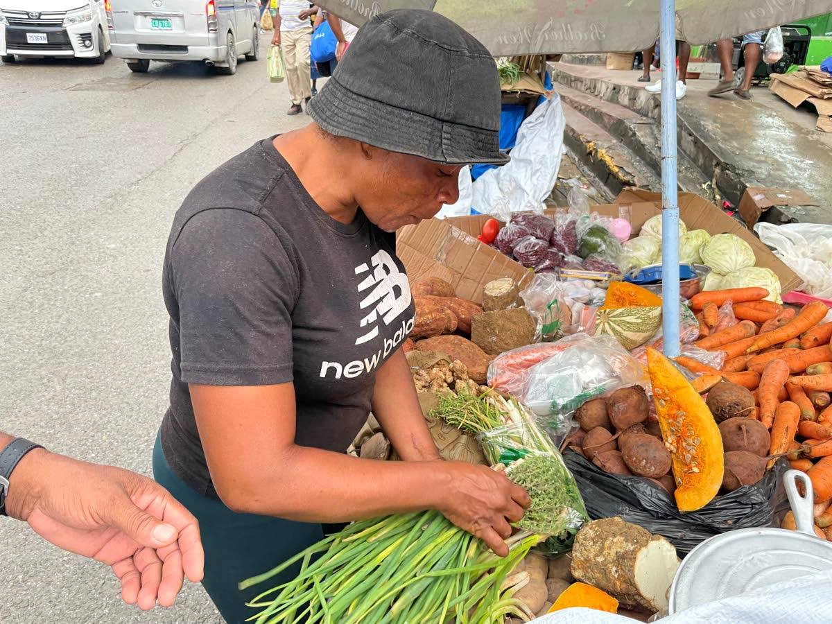Vendor Nickeisha Campbell getting some scallion for a customer.