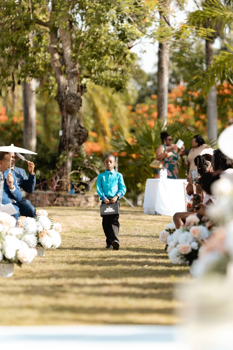 With all the focus of a pro, ring bearer Joshua Collins carried love’s most precious cargo.