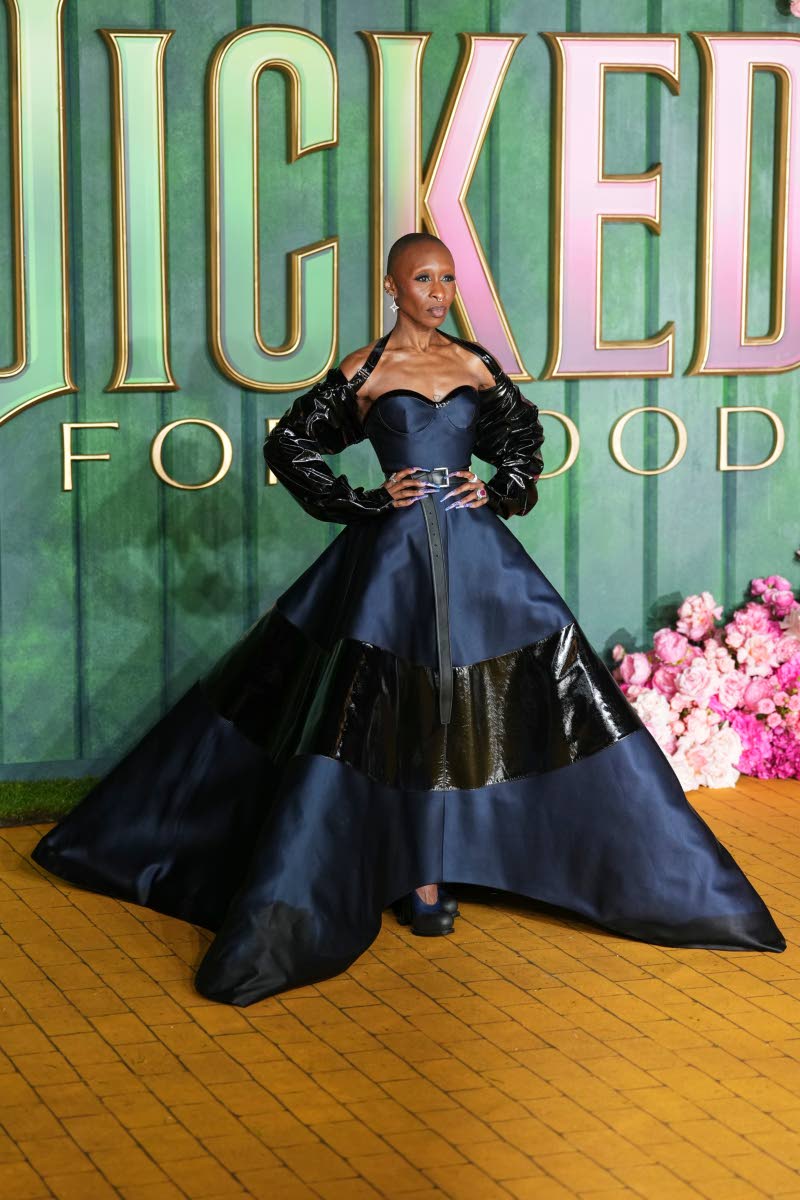 Cynthia Erivo, reprising her role as Elphaba in ‘Wicked: For Good’, stuns in a blue satin Prada dress with a full vinyl-inlaid skirt, cinched with a black leather belt and topped with a sleek vinyl cape.