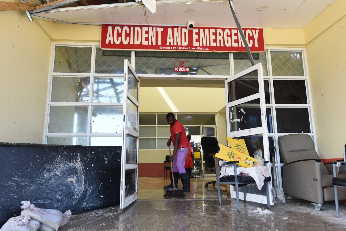 Workers clean the entrance to the Accident and Emergency area at Falmouth Hospital in Trelawny after it was extensively damaged during Hurricane Melissa on October 30.