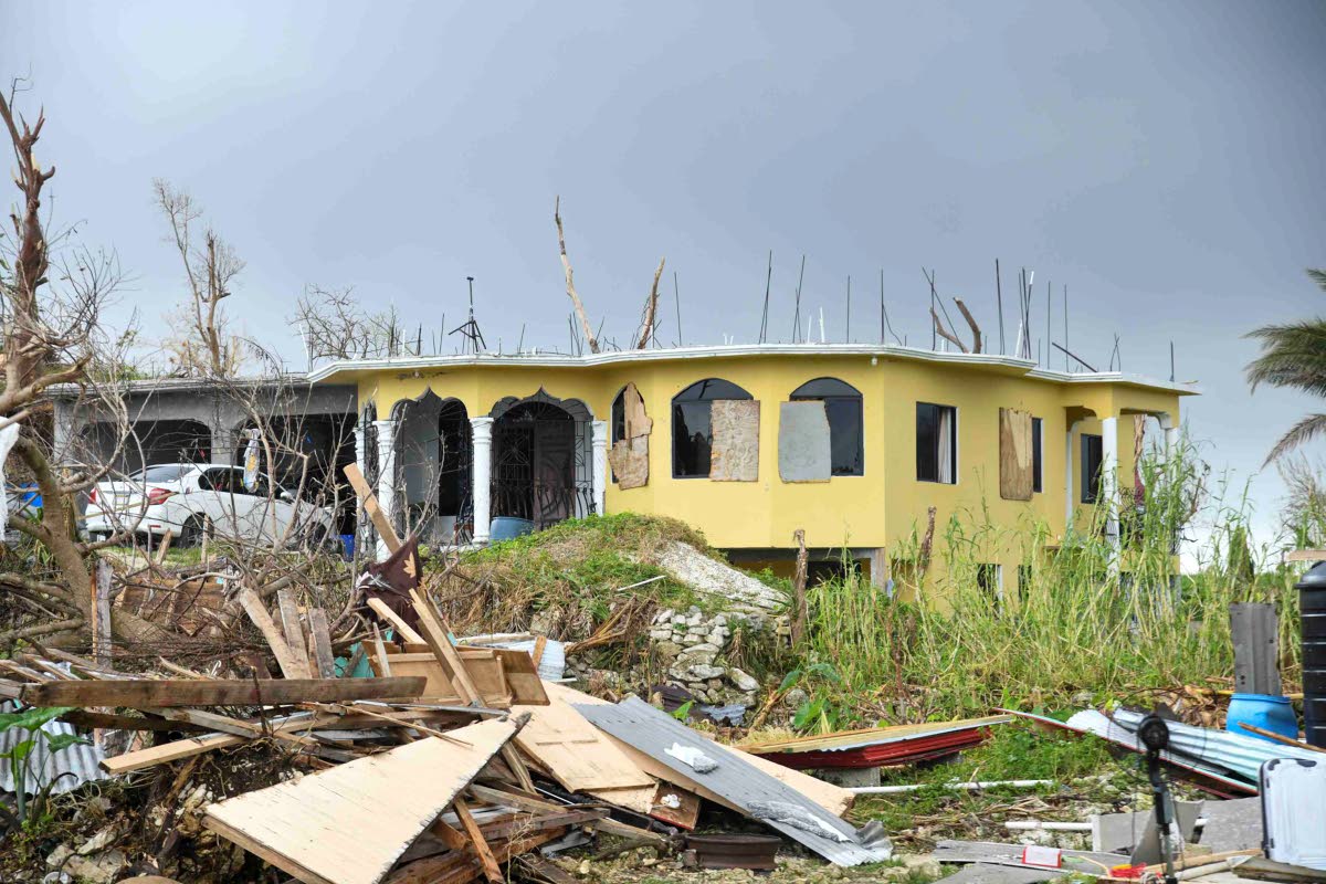 The remains of Crystal Morris’ home (freground) and the neighbour’s house where she sleeps at nights.