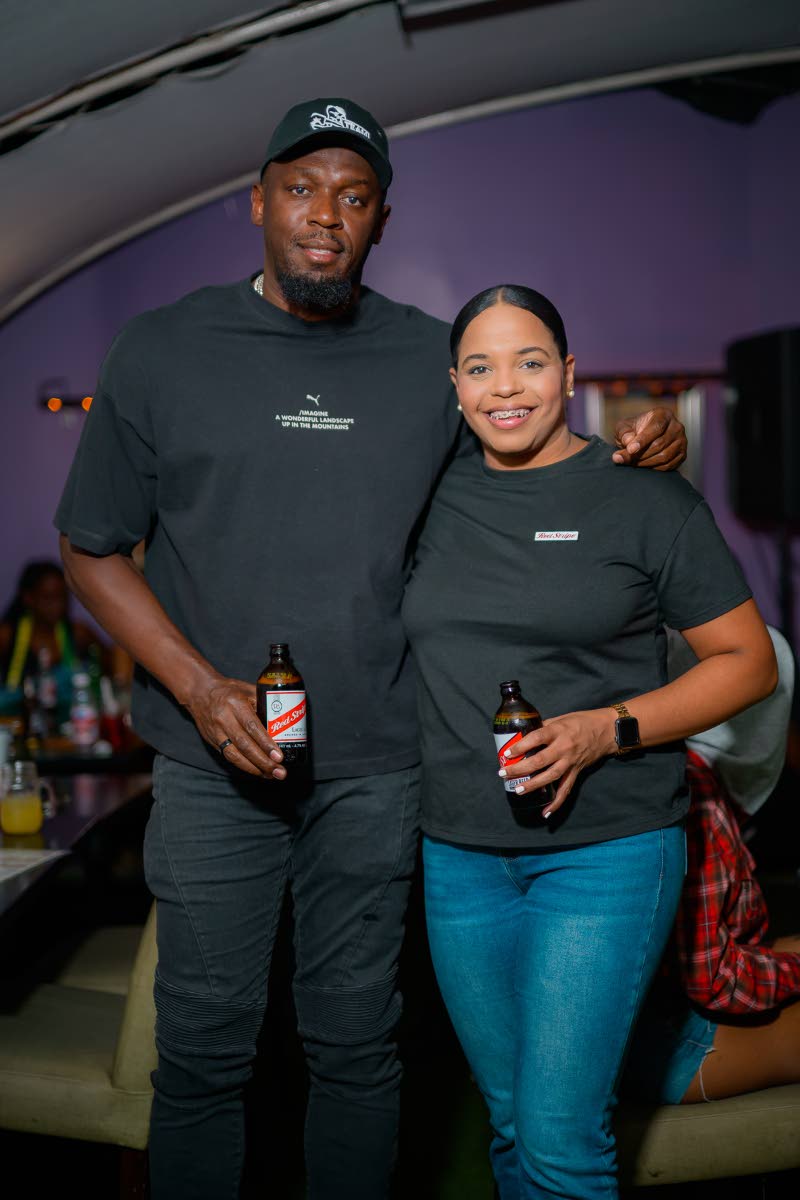 Olympic sprint legend and Red Stripe beer ambassador, Usain Bolt, poses with Red Stripe Brand Manager Amoye Phillpotts-Brown.