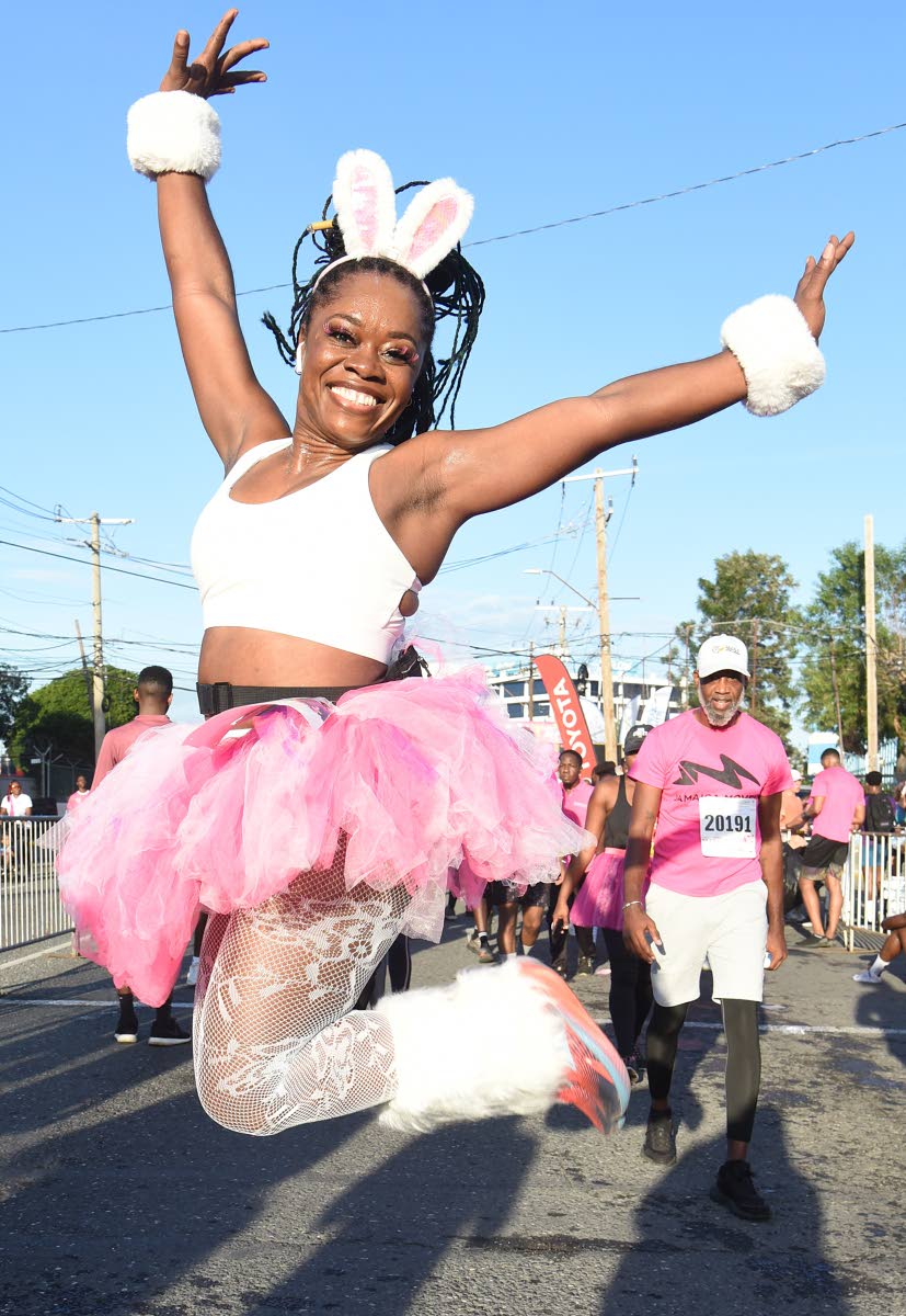 Kim Thompson, cosmetologist at Naturalistic Salon & Spa, leaps into the air in spirited support of breast cancer awareness.