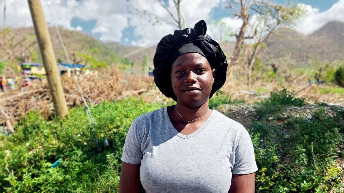 Kasia Neil stands amid the remains of her house, destroyed during the passage of Hurricane Melissa last month.