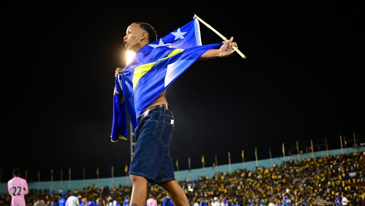 A Curacao fan invades the field at the National Stadium in celebration of watching his team earn a draw against the Reggaee Boyz and head to the World Cup. 