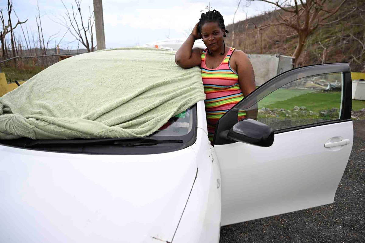 Ann-Marie Warren stands beside the car she has been sleeping in since the passage of Hurricane Melissa in her Westmoreland community.