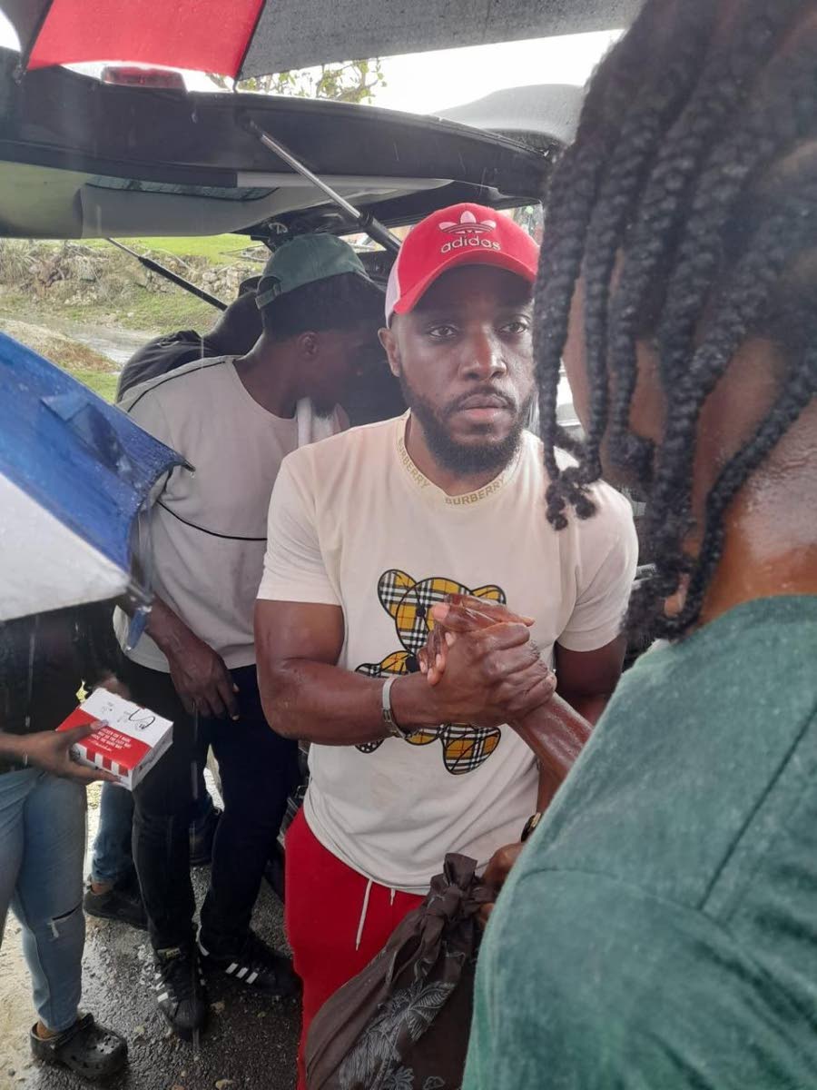 Kevin Downswell (left) shares a moment with a resident of a hurricane-ravaged community during a recent relief tour.