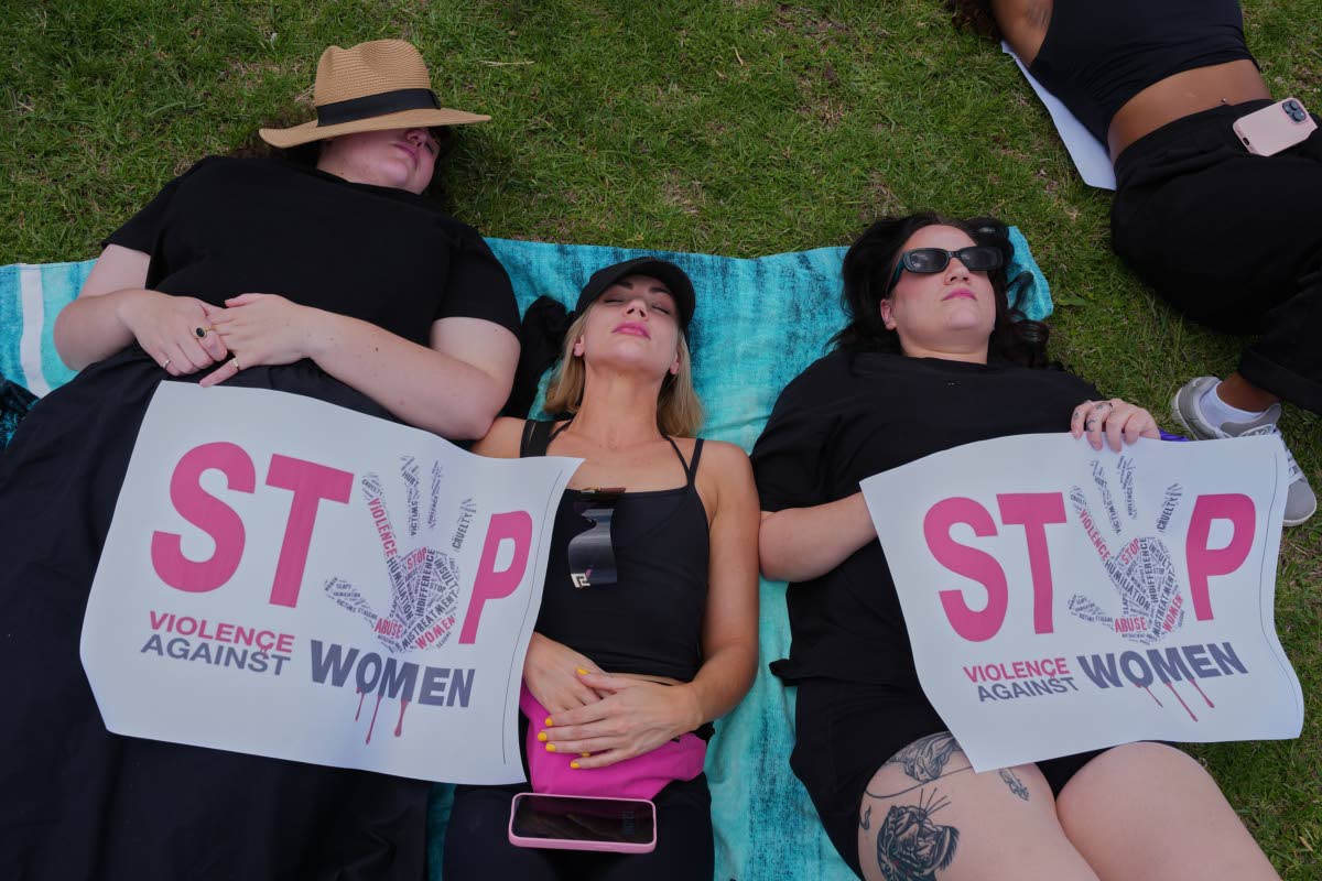 Participants lie on the ground holding signs that read: ‘Stop violence against women’, during a gender-based violence protest at the forecourt of the botanical gardens in Johannesburg, South Africa.