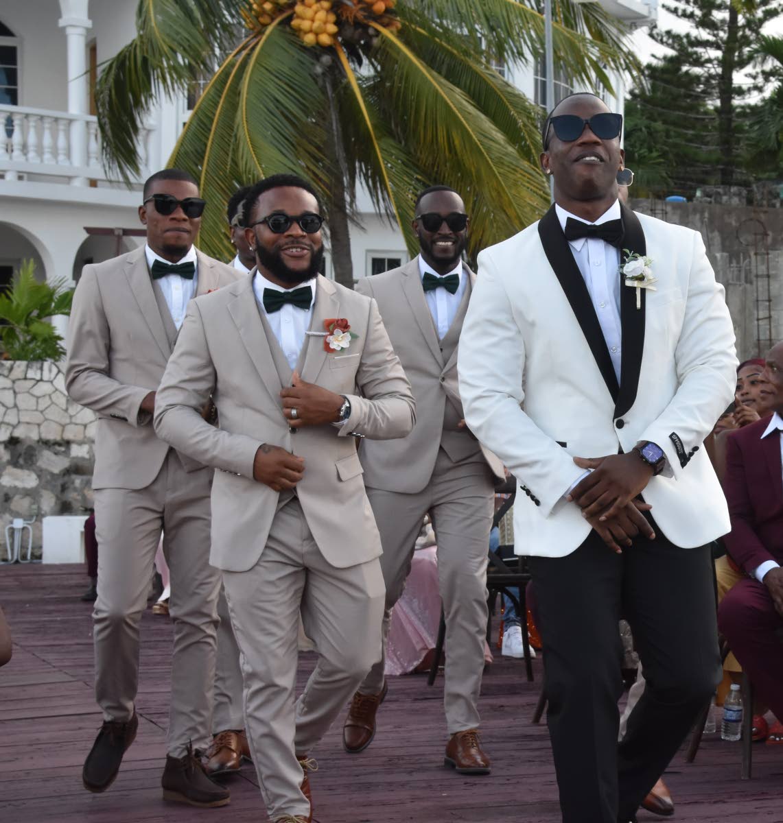 Groom Jevaughn Gaynor (front) makes a lively entrance, dancing down the aisle with his groomsmen by his side.