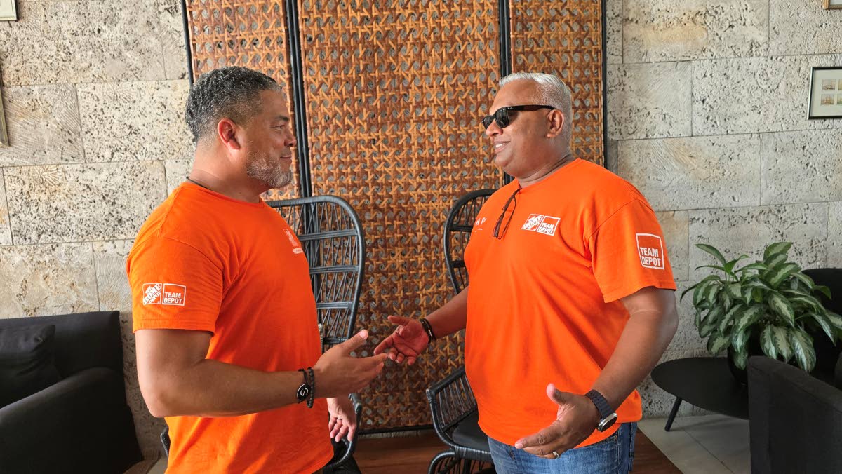 Home Depot’s Warren Cork (left) and Anand Singh in conversation in the lobby of the S Hotel in Montego Bay. 