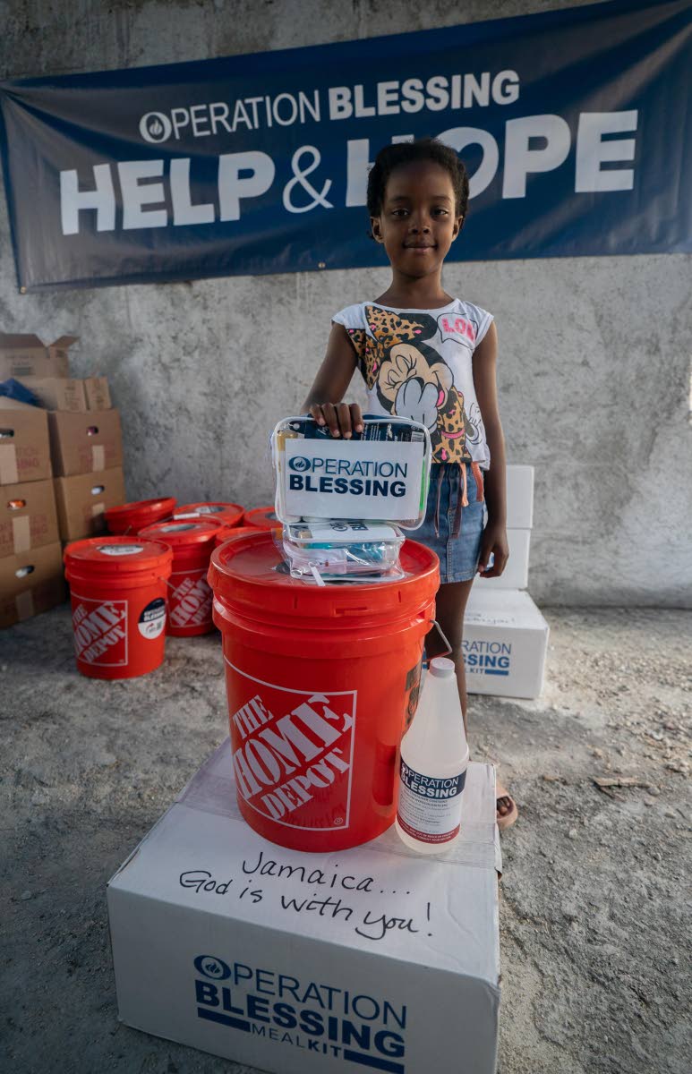 A young child stands tall on gifts received from Home Depot and Operation Blessing.