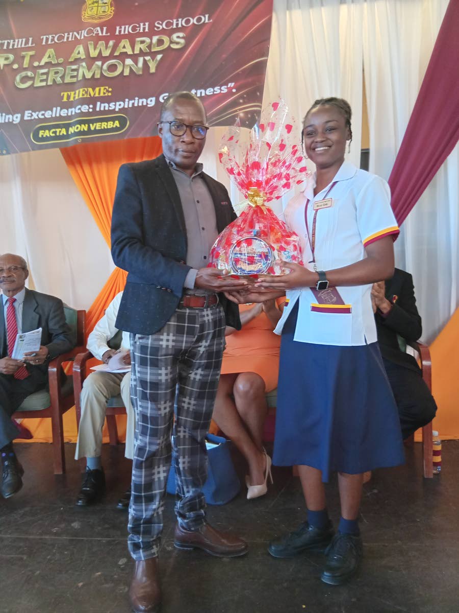 Dinthill Technical High head girl Ruthan Edwards (right) presents a token to guest speaker Leighton Smith during the school’s Parent-Teachers’ Association award ceremony at the Enos Barrett Multi-Purpose Hall, Linstead, on November 19.