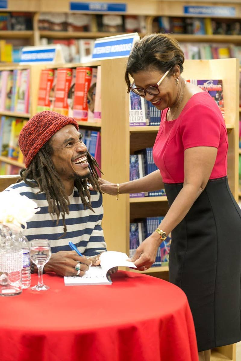 Shepherd pens a note to Kingston Bookshop Director of Corporate Services Sonia Fuller at a book signing for his debut poetry collection, ‘In The Morning Yah’, in February 2019 at the book retailer’s Liguanea branch.