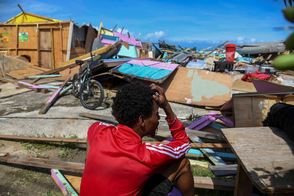 A fisherman in Salem, St Ann, sits among the rubble, holding his head in despair as he surveys damage on the Salem fishing beach during Hurricane Melissa’s passage.