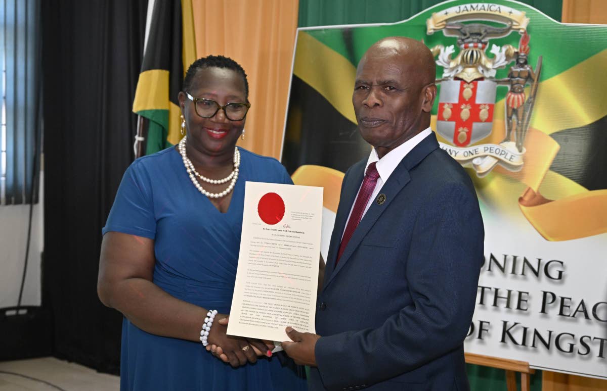 Custos of Kingston, Steadman Fuller (right) presents newly commissioned Justice of the Peace for the parish, Marlene Brooks-Sinclair, with her instrument of appointment, during a commissioning ceremony held on December 4, 2025, Kingston Bookshop, downtown