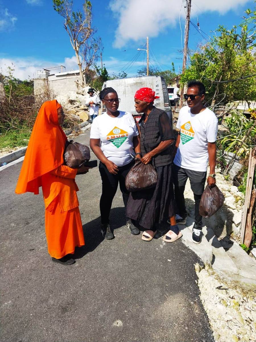 Didi Ananda Devaprana Avadhuta, Principal of the Ananda Marga Basic School and other volunteers distribute relief materials.