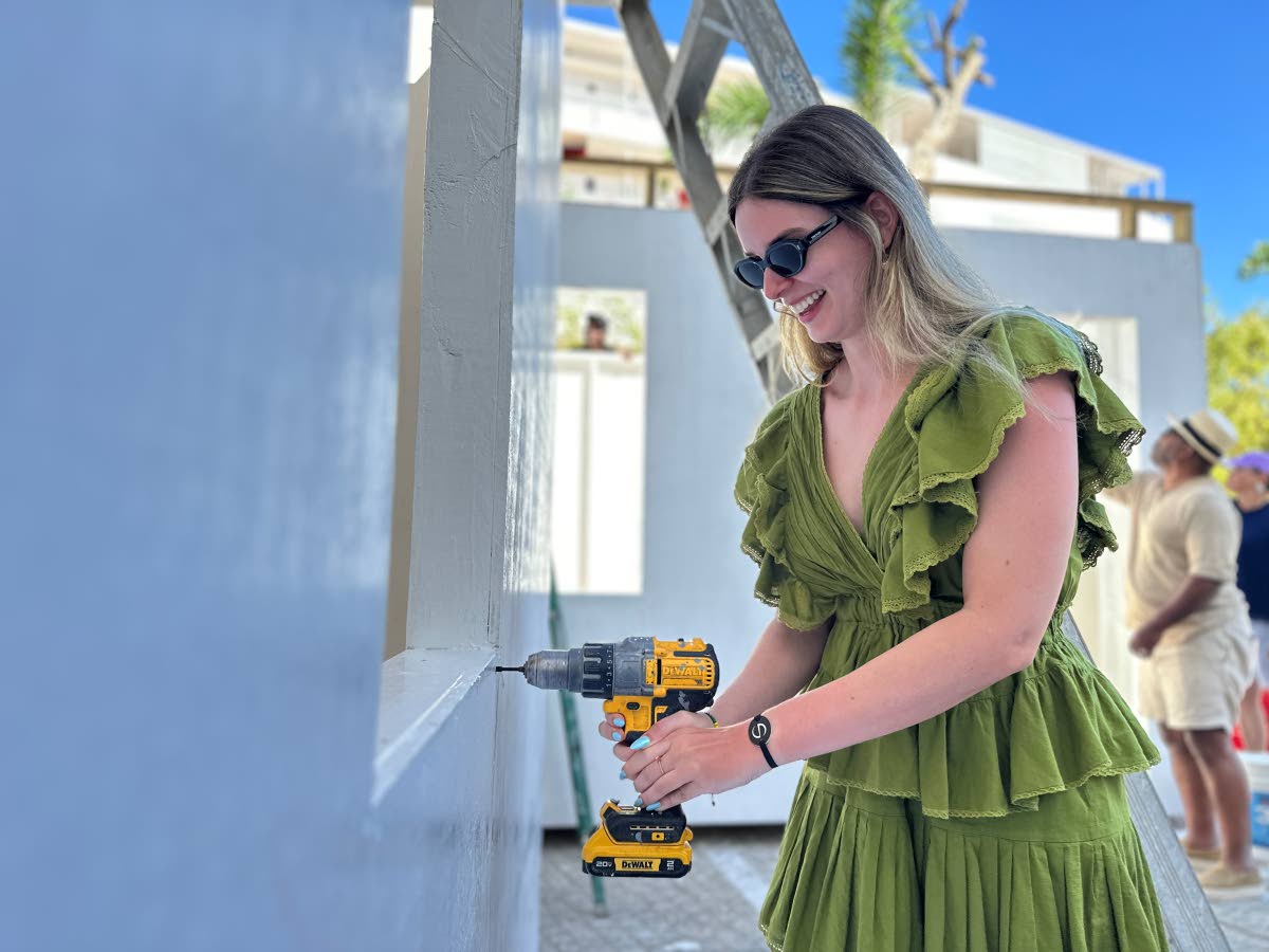 Monica Biazzi, a tourist at the S Hotel Montego Bay, drills a section of one of the 60 homes built by S Hotel Montego in 30 days for families displaced by Hurricane Melissa at S Hotel Montego.