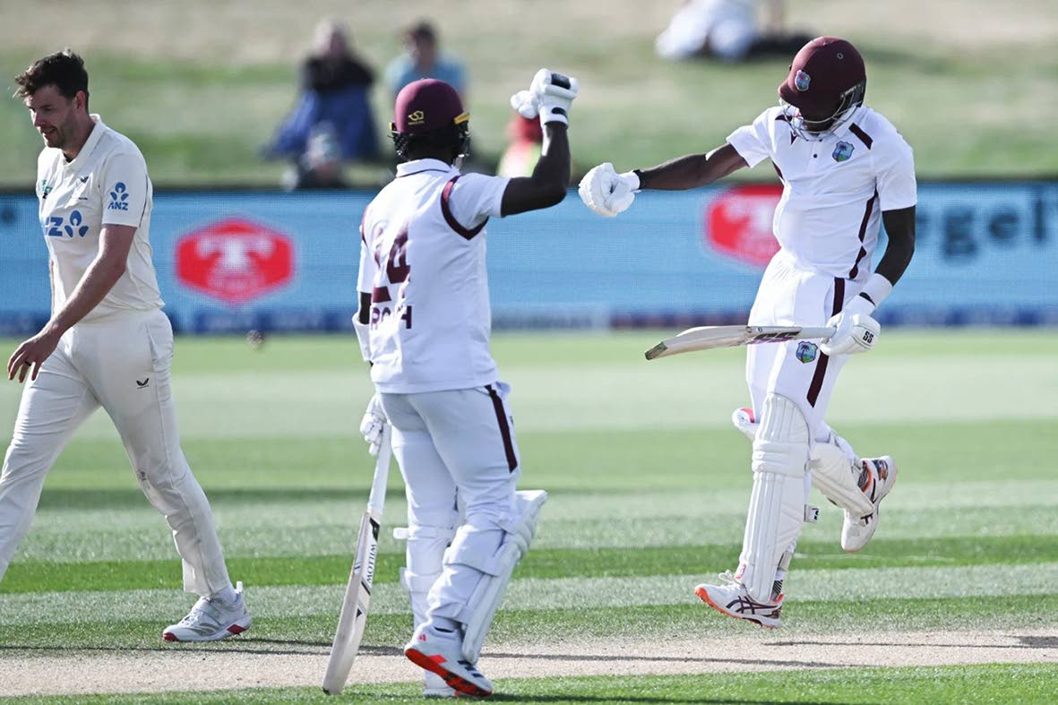 West Indies’ Justin Greaves (right) celebrates with teammate Kemar Roach (centre) after scoring 200 runs against New Zealand on day five of their cricket Test match in Christchurch, New Zealand, on Saturday.