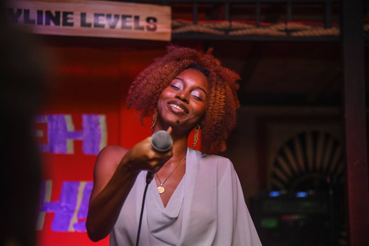 Rising artiste and songwriter Akina Eman points the mic to the crowd to sing along.
