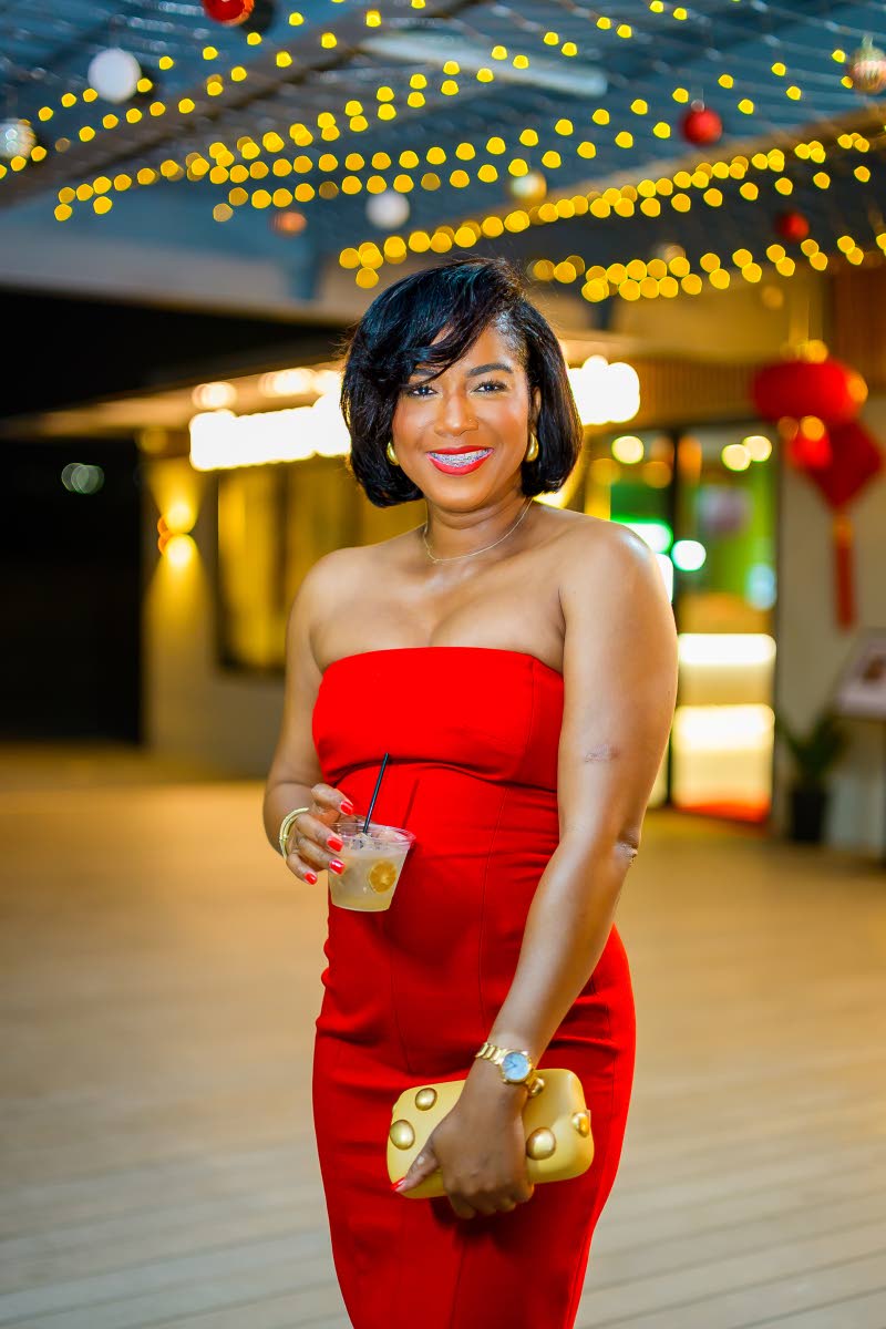 Tyheissa Williams, brand and corporate public relations manager at Red Stripe, radiates confidence in a striking red strapless dress and gold accessories. 