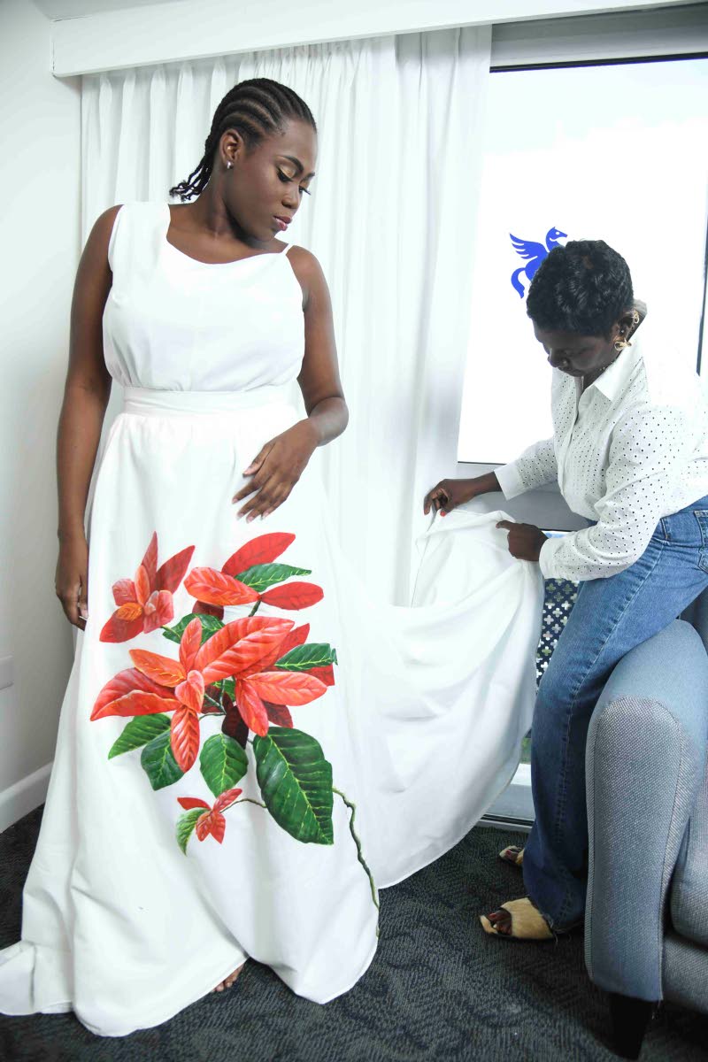 Designer Angella Wilkinson (right), fans the hemline of her cotton blouson creation worn by SAINT International Shanice Thompson.