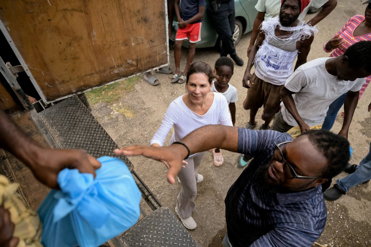 Left: Stewart’s Automotive Group Managing Director, Jacqueline Stewart Lechler (centre), helps deliver care packages to families in Westmoreland impacted by Hurricane Melissa. 
